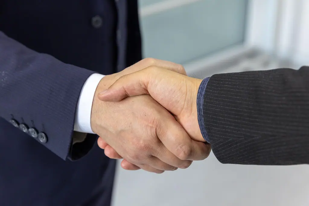 Two business partners in suits shaking hands